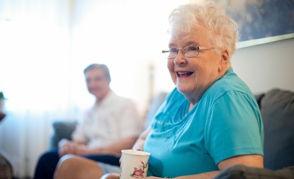 woman drinking coffee talking to friends in living room