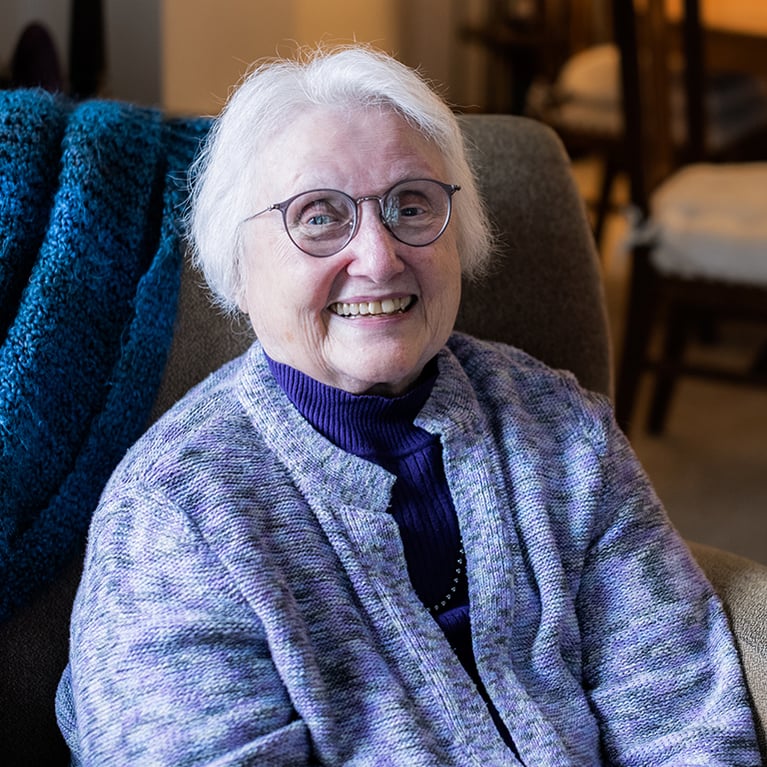 Shelley Wiggins sitting and smiling in chair
