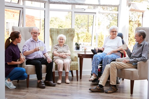 group of seniors sitting in sunny room and talking