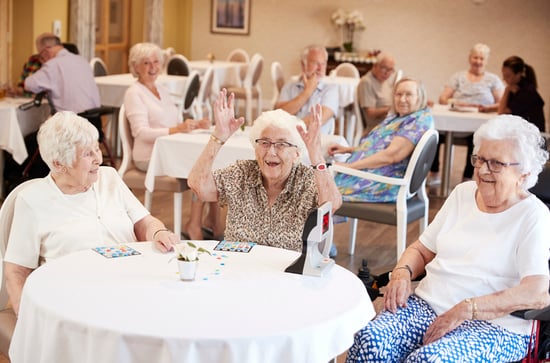 woman in dining room laughing around a table