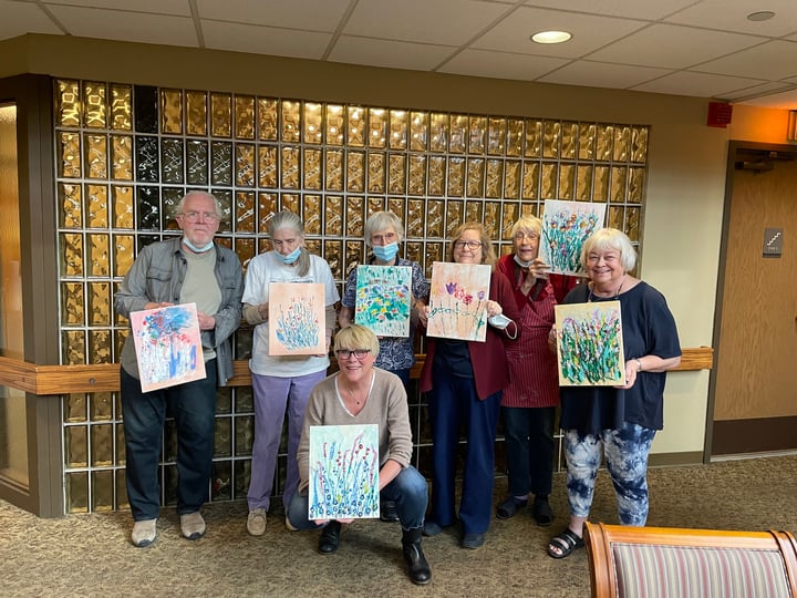 Members holding their paintings