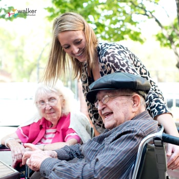 Senior man in wheelchair laughs at table staff member