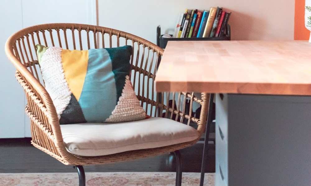 chair with a pillow pulled up to a table