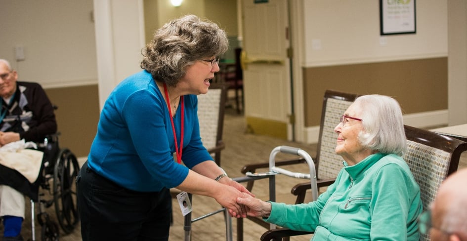 staff holding hands and talking with resident